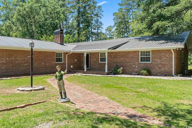 1043 S Main St, Aynor, SC 29511 - ranch-style home with a front yard, a chimney, brick siding, and metal roof