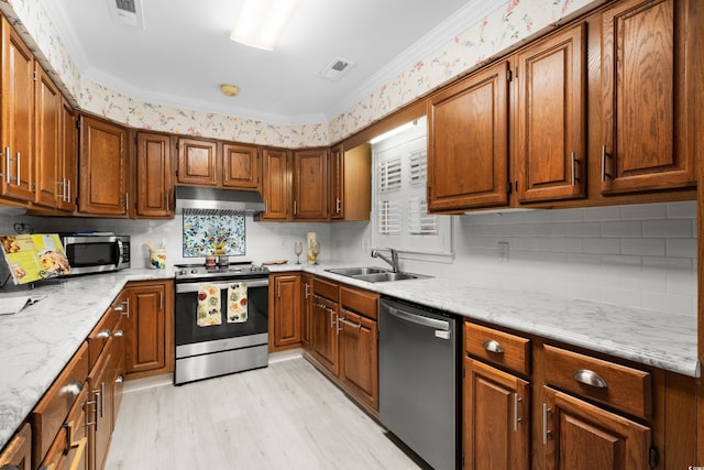 578 Circle Dr, Myrtle Beach, SC 29575 - kitchen featuring stainless steel appliances, a sink, under cabinet range hood, light wood-style flooring, and brown cabinets