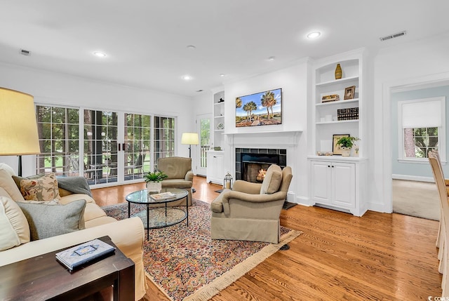 179 Golden Bear Dr Unit C4, Pawleys Island, SC 29585 - living area featuring light wood-type flooring, a tile fireplace, healthy amount of natural light, built in features, and recessed lighting