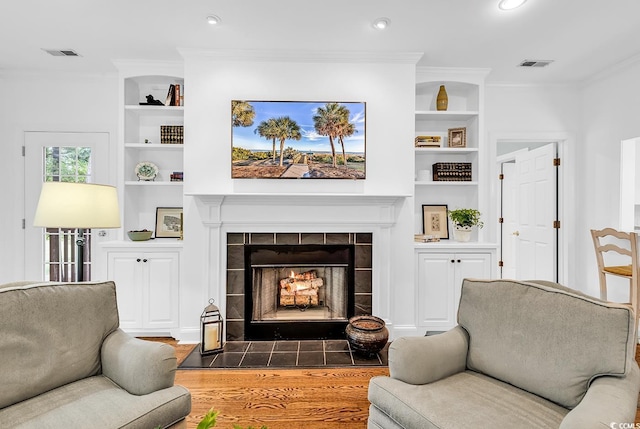 179 Golden Bear Dr Unit C4, Pawleys Island, SC 29585 - living room with built in shelves, ornamental molding, a tiled fireplace, wood finished floors, and recessed lighting