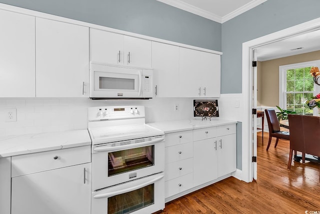 179 Golden Bear Dr Unit C4, Pawleys Island, SC 29585 - kitchen with white appliances, crown molding, wood finished floors, backsplash, and white cabinetry