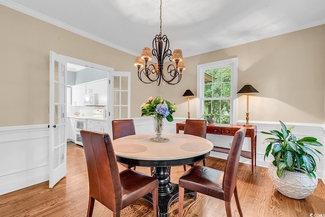 179 Golden Bear Dr Unit C4, Pawleys Island, SC 29585 - dining area with a chandelier, a wainscoted wall, ornamental molding, and light wood finished floors