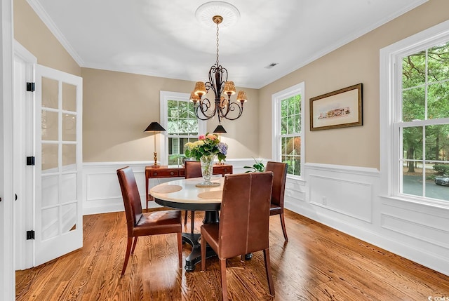 179 Golden Bear Dr Unit C4, Pawleys Island, SC 29585 - dining room with wainscoting, wood finished floors, a chandelier, ornamental molding, and a decorative wall