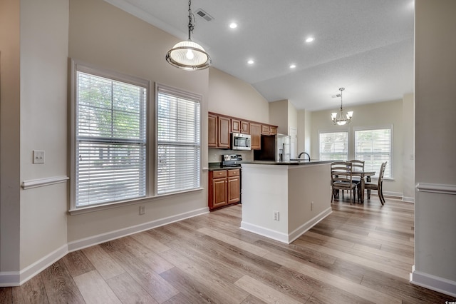 205 Threshing Way Unit 1052, Myrtle Beach, SC 29579 - kitchen featuring appliances with stainless steel finishes, a chandelier, dark countertops, brown cabinets, and an island with sink