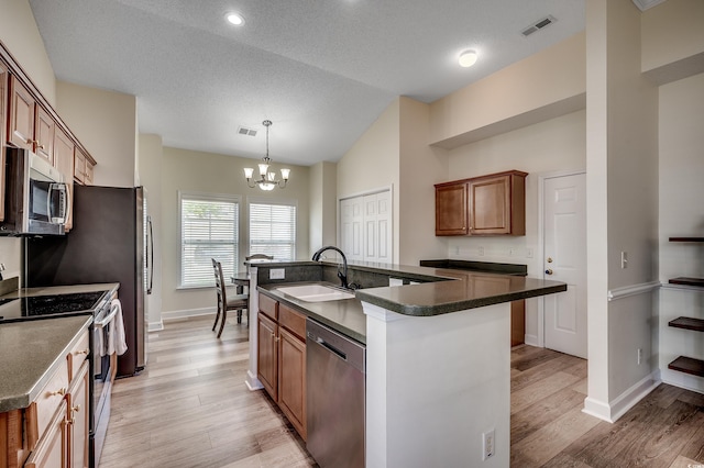 205 Threshing Way Unit 1052, Myrtle Beach, SC 29579 - kitchen with stainless steel appliances, a sink, dark countertops, a chandelier, and light wood-type flooring