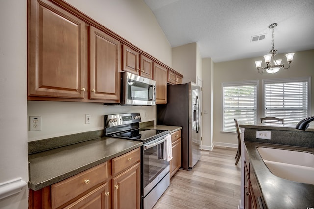 205 Threshing Way Unit 1052, Myrtle Beach, SC 29579 - kitchen featuring stainless steel appliances, dark countertops, a sink, light wood-style floors, and a chandelier