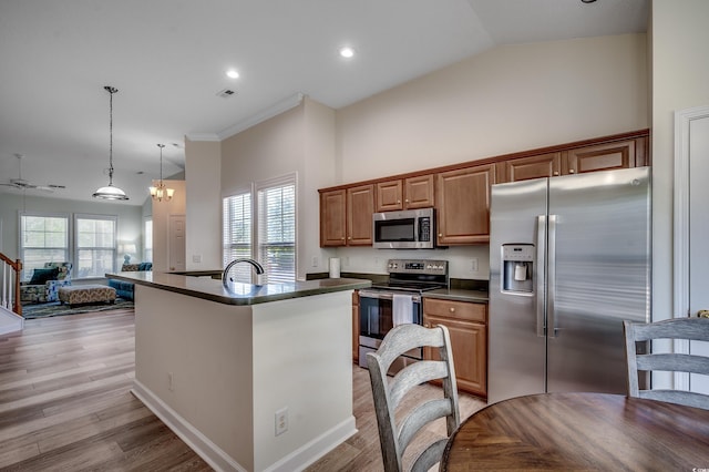 205 Threshing Way Unit 1052, Myrtle Beach, SC 29579 - kitchen featuring stainless steel appliances, dark countertops, light wood-style floors, brown cabinetry, and open floor plan