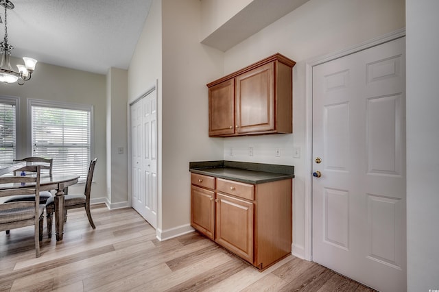 205 Threshing Way Unit 1052, Myrtle Beach, SC 29579 - kitchen featuring dark countertops, a chandelier, light wood-style flooring, baseboards, and brown cabinetry