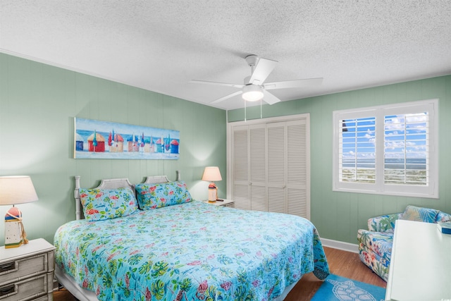 6309 N Ocean Blvd Unit 14E, North Myrtle Beach, SC 29582 - bedroom featuring wood finished floors, a textured ceiling, a closet, baseboards, and ceiling fan