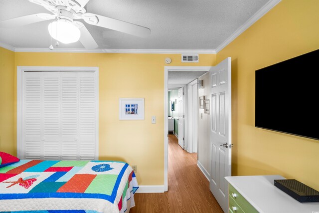 6309 N Ocean Blvd Unit 14E, North Myrtle Beach, SC 29582 - bedroom with wood finished floors, a textured ceiling, crown molding, a closet, and ceiling fan