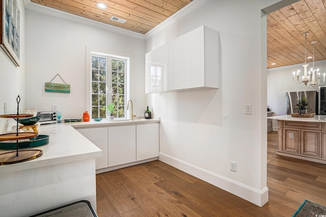 139 Pioneer Loop, Georgetown, SC 29440 - kitchen with wooden ceiling, wood finished floors, recessed lighting, white cabinetry, and light countertops