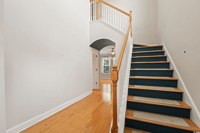 278 Carolina Crossing Blvd, Little River, SC 29566 - stairs featuring hardwood / wood-style floors, arched walkways, and a towering ceiling
