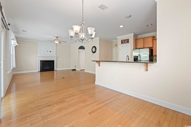 278 Carolina Crossing Blvd, Little River, SC 29566 - unfurnished living room featuring ceiling fan, crown molding, light wood finished floors, a chandelier, and arched walkways