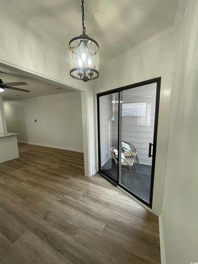 1509 N Waccamaw Dr Unit 112, Murrells Inlet, SC 29576 - unfurnished dining area featuring crown molding, wood finished floors, a chandelier, ceiling fan, and baseboards