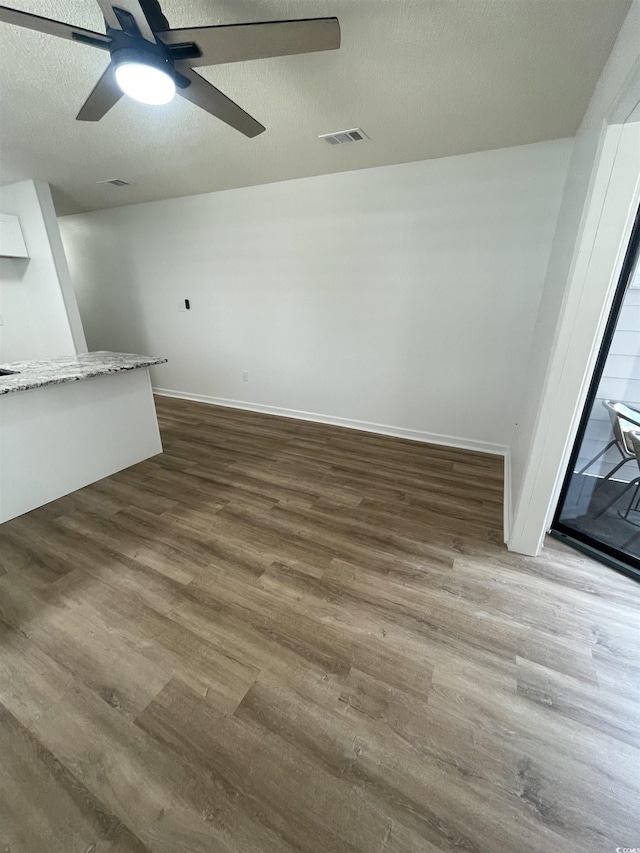1509 N Waccamaw Dr Unit 112, Murrells Inlet, SC 29576 - unfurnished living room with wood finished floors, a ceiling fan, baseboards, and a textured ceiling