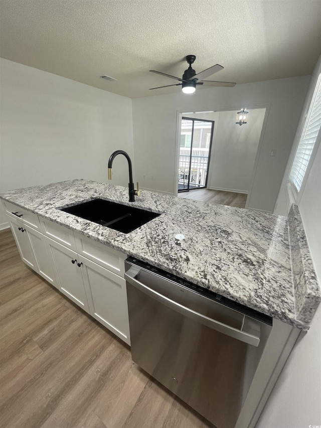 1509 N Waccamaw Dr Unit 112, Murrells Inlet, SC 29576 - kitchen featuring stainless steel dishwasher, a sink, light wood-style flooring, a ceiling fan, and a textured ceiling