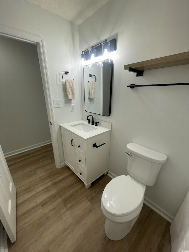 1509 N Waccamaw Dr Unit 112, Murrells Inlet, SC 29576 - bathroom with vanity, wood finished floors, toilet, baseboards, and a textured ceiling