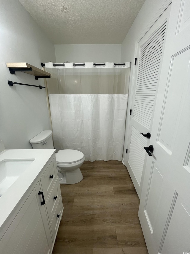 1509 N Waccamaw Dr Unit 112, Murrells Inlet, SC 29576 - full bathroom featuring wood finished floors, toilet, vanity, a textured ceiling, and a shower with shower curtain