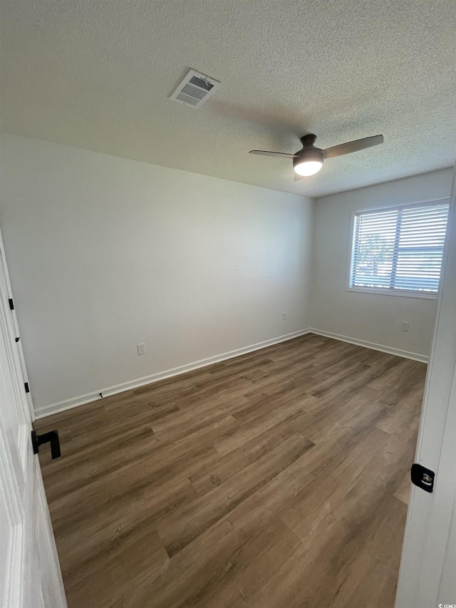 1509 N Waccamaw Dr Unit 112, Murrells Inlet, SC 29576 - empty room featuring dark wood-style flooring, a ceiling fan, baseboards, and a textured ceiling