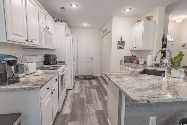 359 Harbour Reef Dr, Myrtle Beach, SC 29588 - kitchen with white appliances, a sink, a peninsula, white cabinetry, and recessed lighting