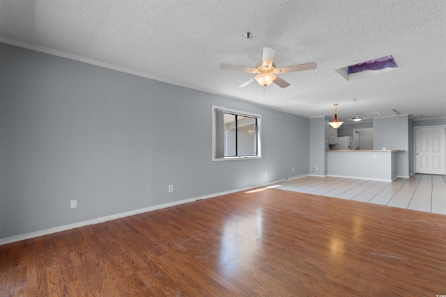 4350 Intercoastal Dr Unit 2408, Little River, SC 29566 - unfurnished living room featuring a ceiling fan, a textured ceiling, light wood finished floors, crown molding, and baseboards