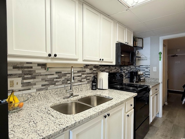 1501 S Ocean Blvd Unit 239, Myrtle Beach, SC 29577 - kitchen featuring black appliances, a sink, white cabinets, light wood-type flooring, and backsplash