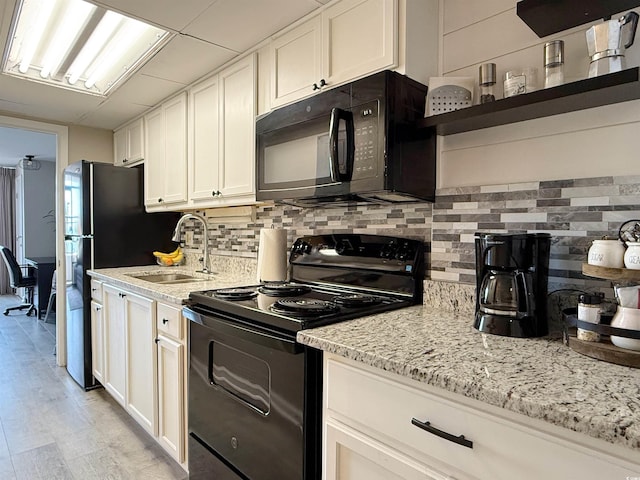 1501 S Ocean Blvd Unit 239, Myrtle Beach, SC 29577 - kitchen with black appliances, a sink, tasteful backsplash, and light stone counters