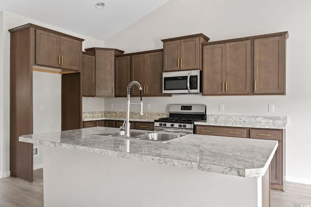 417 Grain Field Dr, Georgetown, SC 29440 - kitchen with stainless steel appliances, a sink, light wood finished floors, vaulted ceiling, and light countertops