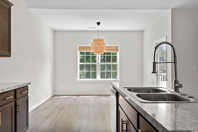 417 Grain Field Dr, Georgetown, SC 29440 - kitchen featuring a sink, light wood-type flooring, dark brown cabinets, hanging light fixtures, and baseboards