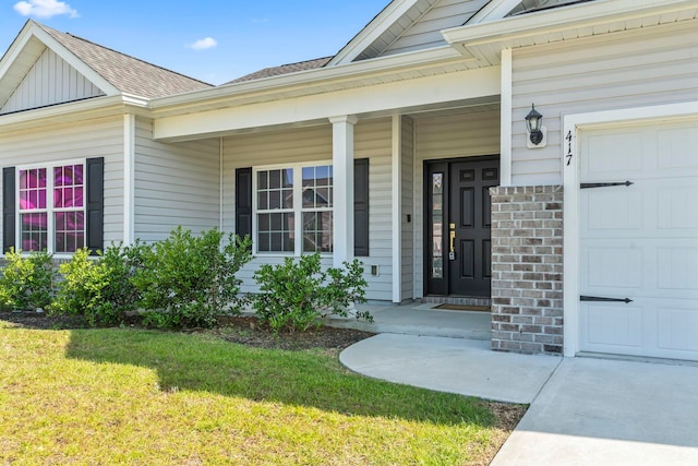 417 Grain Field Dr, Georgetown, SC 29440 - doorway to property with a lawn, a garage, a shingled roof, a porch, and brick siding
