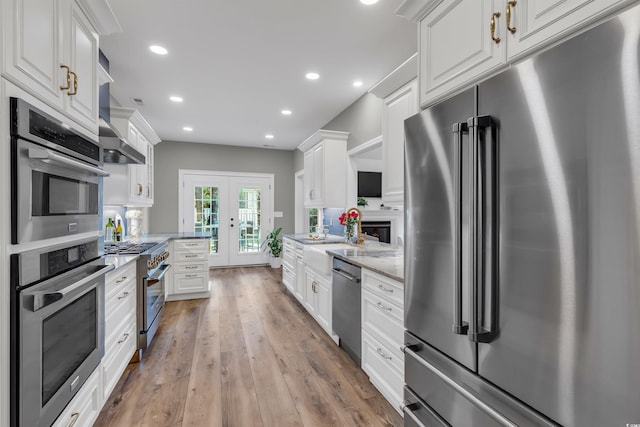 2150 N Berwick Dr, Myrtle Beach, SC 29575 - kitchen featuring premium appliances, french doors, white cabinets, light wood finished floors, and recessed lighting