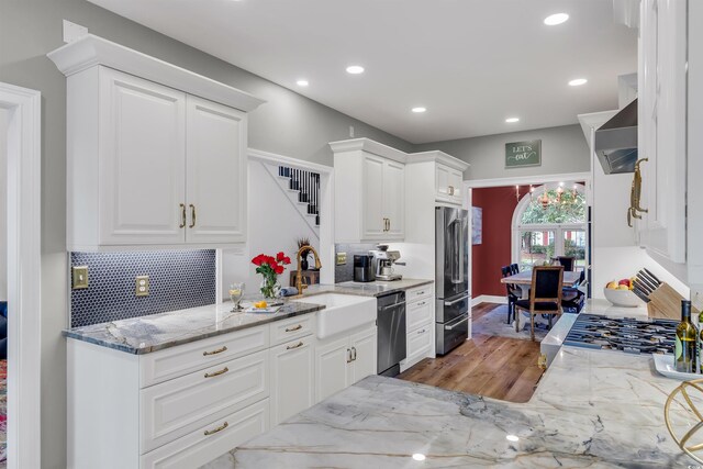 2150 N Berwick Dr, Myrtle Beach, SC 29575 - kitchen featuring stainless steel appliances, a sink, wood finished floors, backsplash, and white cabinets