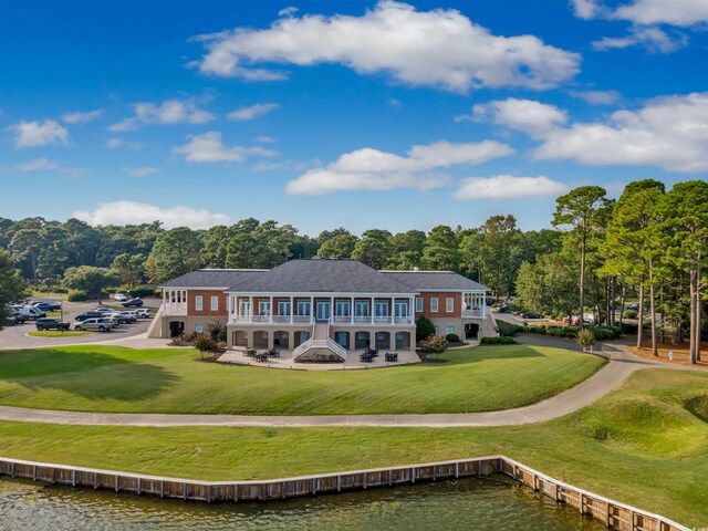 2150 N Berwick Dr, Myrtle Beach, SC 29575 - rear view of house featuring a balcony, a water view, stairway, and a lawn