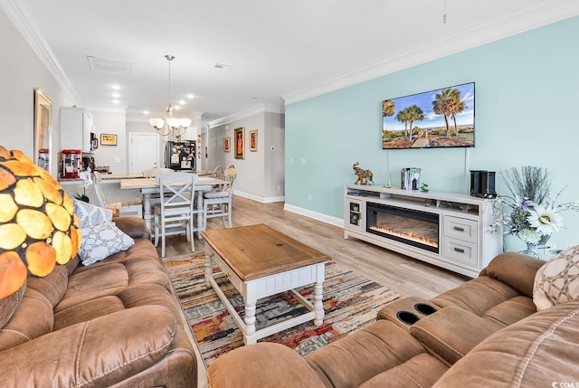 232 Je Edward Dr Unit 19, Myrtle Beach, SC 29588 - living area with a chandelier, crown molding, light wood-style floors, baseboards, and a glass covered fireplace