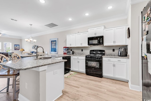 232 Je Edward Dr Unit 19, Myrtle Beach, SC 29588 - kitchen with black appliances, a sink, a breakfast bar, white cabinets, and backsplash