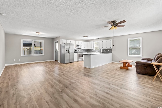 204 Elm St, Johnsonville, SC 29555 - living room featuring a ceiling fan, light wood finished floors, a textured ceiling, and baseboards