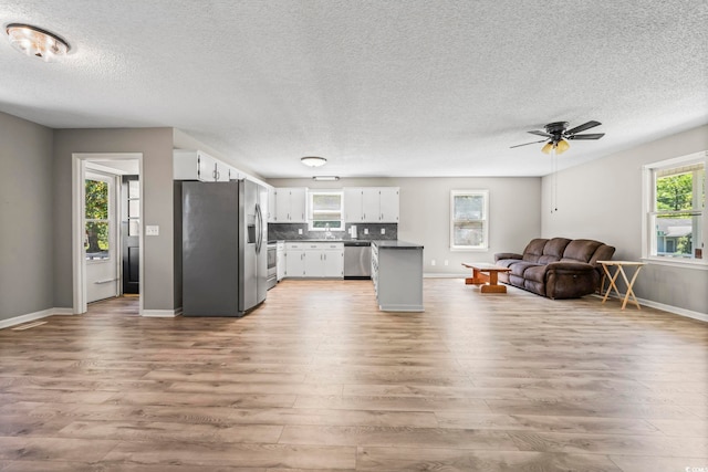 204 Elm St, Johnsonville, SC 29555 - kitchen featuring open floor plan, appliances with stainless steel finishes, light wood-style flooring, white cabinets, and a textured ceiling