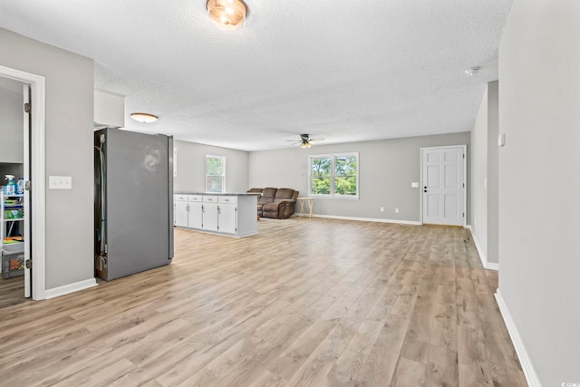204 Elm St, Johnsonville, SC 29555 - unfurnished living room with a textured ceiling, ceiling fan, light wood-type flooring, and baseboards