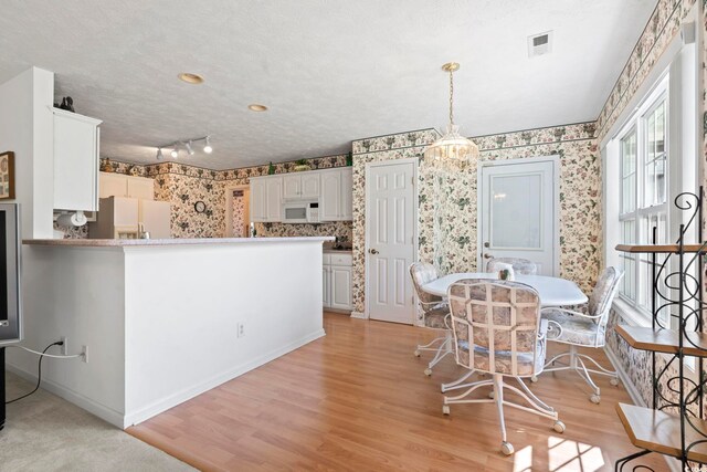 4012 Grousewood Dr, Myrtle Beach, SC 29588 - dining area with wallpapered walls, light wood-type flooring, and baseboards