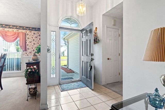 4012 Grousewood Dr, Myrtle Beach, SC 29588 - foyer entrance with a chandelier, a textured ceiling, light carpet, wallpapered walls, and light tile patterned floors
