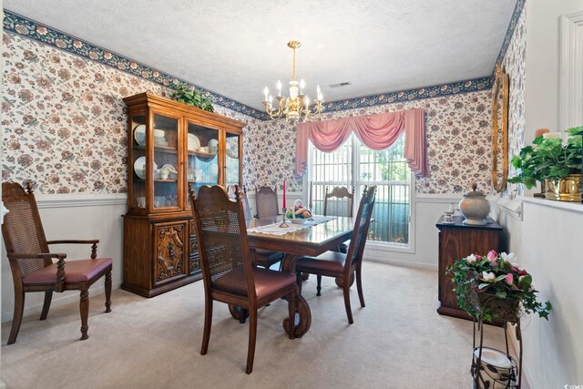 4012 Grousewood Dr, Myrtle Beach, SC 29588 - dining space featuring wallpapered walls, a chandelier, wainscoting, a textured ceiling, and light carpet
