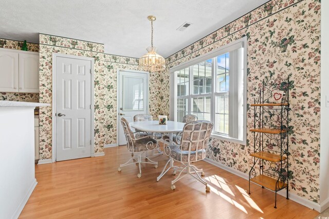 4012 Grousewood Dr, Myrtle Beach, SC 29588 - dining space featuring wallpapered walls, baseboards, light wood-type flooring, and a textured ceiling