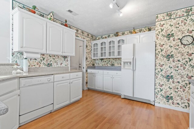 4012 Grousewood Dr, Myrtle Beach, SC 29588 - kitchen featuring wallpapered walls, white appliances, light wood-type flooring, white cabinets, and a textured ceiling