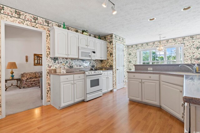 4012 Grousewood Dr, Myrtle Beach, SC 29588 - kitchen with wallpapered walls, white appliances, white cabinets, light wood finished floors, and a sink
