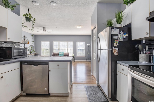 3939 Gladiola Ct Unit 202, Myrtle Beach, SC 29588 - kitchen with stainless steel appliances, a ceiling fan, light wood-style flooring, a textured ceiling, and a peninsula