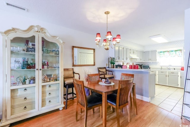 1437 Baldwin Ct Unit 1437, Little River, SC 29566 - dining room featuring a chandelier and light wood-type flooring