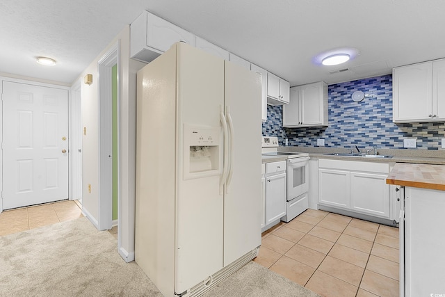 600 Deer Creek Rd Unit D, Surfside Beach, SC 29575 - kitchen with white appliances, a sink, light tile patterned floors, white cabinetry, and backsplash