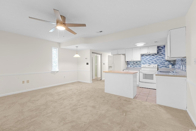 600 Deer Creek Rd Unit D, Surfside Beach, SC 29575 - kitchen featuring white appliances, light carpet, a sink, a kitchen island, and a ceiling fan