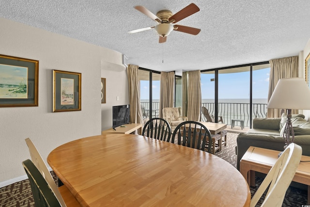 2500 N Ocean Blvd Unit 601, Myrtle Beach, SC 29577 - dining space featuring a textured ceiling, a ceiling fan, a wall of windows, a textured wall, and baseboards