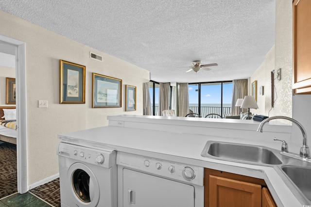 2500 N Ocean Blvd Unit 601, Myrtle Beach, SC 29577 - laundry area with a sink, washing machine and clothes dryer, a textured ceiling, ceiling fan, and a water view
